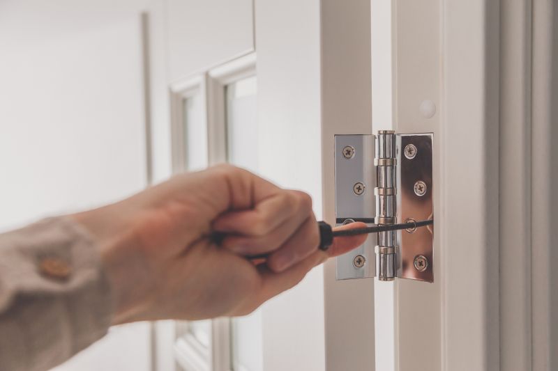 Handyman repairing a door hinge